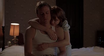 Movie still from “Brokeback Mountain” (2005), directed by Ang Lee – A man and a woman hugging in a bedroom; Medium shot, Over the shoulder angle