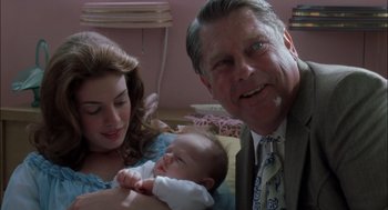 Movie still from “Brokeback Mountain” (2005), directed by Ang Lee – An older man and woman holding a baby in a room; Close Up shot, Over the shoulder angle