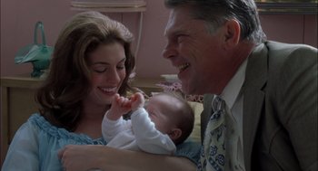 Movie still from “Brokeback Mountain” (2005), directed by Ang Lee – An older man and woman holding a baby in his arms; Close Up shot, Over the shoulder angle