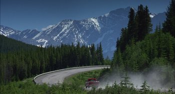 Movie still from “Brokeback Mountain” (2005), directed by Ang Lee – A red truck driving down a curvy road in the mountains; Extreme Wide shot, High angle