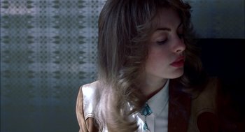 Movie still from “Brokeback Mountain” (2005), directed by Ang Lee – A woman with long brown hair wearing a white shirt and a tie; Close Up shot, Overhead angle