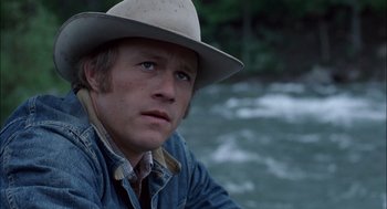 Movie still from “Brokeback Mountain” (2005), directed by Ang Lee – A person wearing a hat near a body of water; Close Up shot, Low angle