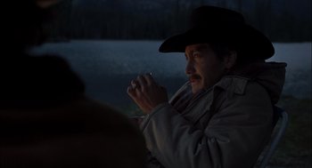 Movie still from “Brokeback Mountain” (2005), directed by Ang Lee – A man in a cowboy hat is sitting in the dark; Medium shot, Over the shoulder angle