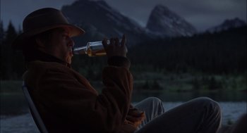 Movie still from “Brokeback Mountain” (2005), directed by Ang Lee – A man drinking a beer while sitting in a chair; Medium shot, Low angle