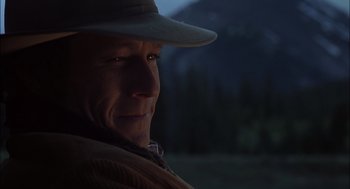 Movie still from “Brokeback Mountain” (2005), directed by Ang Lee – A person wearing a hat with mountains in the background; Close Up shot, Over the shoulder angle