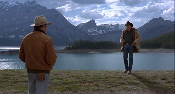 Movie still from “Brokeback Mountain” (2005), directed by Ang Lee – Two men standing in front of a body of water; Wide shot, Over the shoulder angle
