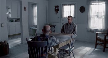 Movie still from “Brokeback Mountain” (2005), directed by Ang Lee – Two men are sitting at a table in a room; Wide shot, Over the shoulder angle