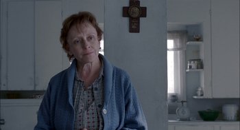 Movie still from “Brokeback Mountain” (2005), directed by Ang Lee – An older woman standing in front of a cross; Close Up shot, Over the shoulder angle