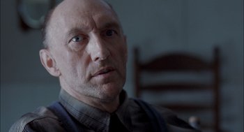 Movie still from “Brokeback Mountain” (2005), directed by Ang Lee – An older man with a bald head looking at the camera; Close Up shot, Low angle