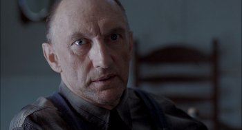 Movie still from “Brokeback Mountain” (2005), directed by Ang Lee – An older man with a goatee looking at the camera; Close Up shot, Over the shoulder angle