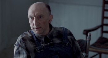 Movie still from “Brokeback Mountain” (2005), directed by Ang Lee – An older man wearing a plaid shirt and overalls; Close Up shot, Over the shoulder angle