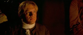 Movie still from “Brotherhood of the Wolf” (2001), directed by Christophe Gans – A person wearing a neck brace; Close Up shot, Over the shoulder angle