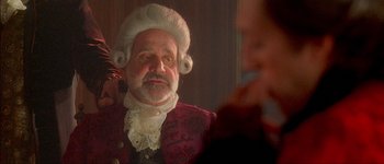 Movie still from “Brotherhood of the Wolf” (2001), directed by Christophe Gans – An older man in a wig and a wig stand in front of a mirror; Close Up shot, Over the shoulder angle