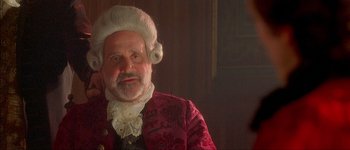 Movie still from “Brotherhood of the Wolf” (2001), directed by Christophe Gans – An old man in a wig and a red jacket; Close Up shot, Over the shoulder angle