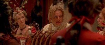 Movie still from “Brotherhood of the Wolf” (2001), directed by Christophe Gans – A man sitting in front of a group of people; Close Up shot, Over the shoulder angle