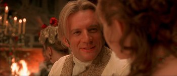 Movie still from “Brotherhood of the Wolf” (2001), directed by Christophe Gans – A person wearing a suit and tie; Close Up shot, Over the shoulder angle