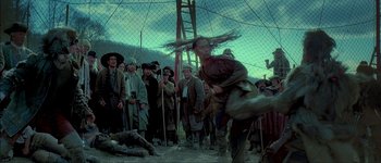 Movie still from “Brotherhood of the Wolf” (2001), directed by Christophe Gans – A group of people standing around a fence; Wide shot, Low angle