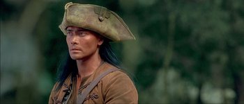 Movie still from “Brotherhood of the Wolf” (2001), directed by Christophe Gans – A man in a pirate hat is standing in the woods; Close Up shot, Over the shoulder angle