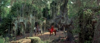 Movie still from “Brotherhood of the Wolf” (2001), directed by Christophe Gans – Two people riding horses through the woods on a sunny day; Extreme Wide shot, Low angle