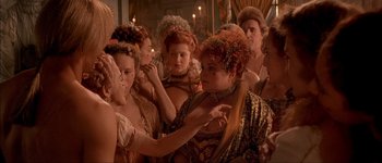 Movie still from “Brotherhood of the Wolf” (2001), directed by Christophe Gans – A group of people gathered around a woman; Medium shot, Over the shoulder angle