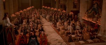 Movie still from “Brotherhood of the Wolf” (2001), directed by Christophe Gans – A large group of people sitting in a large room; Extreme Wide shot, High angle