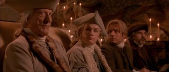 Movie still from “Brotherhood of the Wolf” (2001), directed by Christophe Gans – A group of people sitting next to each other in a room; Medium shot, Low angle