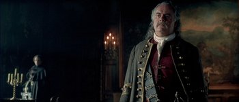 Movie still from “Brotherhood of the Wolf” (2001), directed by Christophe Gans – A man in a pirate costume standing in a room; Medium shot, Low angle