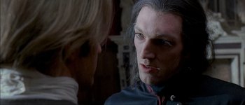 Movie still from “Brotherhood of the Wolf” (2001), directed by Christophe Gans – A man with long grey hair looking at another man with long grey hair; Close Up shot, Over the shoulder angle