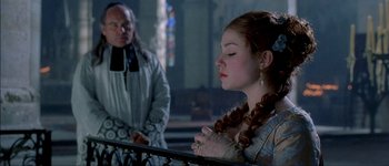 Movie still from “Brotherhood of the Wolf” (2001), directed by Christophe Gans – A young woman is praying in front of an older man; Close Up shot, Over the shoulder angle