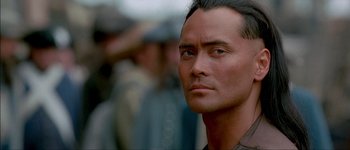 Movie still from “Brotherhood of the Wolf” (2001), directed by Christophe Gans – A person wearing a suit and tie; Close Up shot, Over the shoulder angle