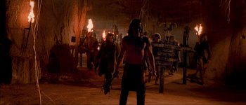 Movie still from “Brotherhood of the Wolf” (2001), directed by Christophe Gans – A group of people walking in a cave with torches; Wide shot, Low angle
