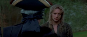 Movie still from “Brotherhood of the Wolf” (2001), directed by Christophe Gans – A man with long blonde hair is looking at a woman; Close Up shot, Over the shoulder angle