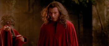 Movie still from “Brotherhood of the Wolf” (2001), directed by Christophe Gans – A man with long hair wearing a red cape; Close Up shot, Over the shoulder angle