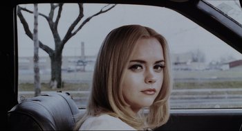 A woman sitting in the back seat of a car