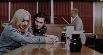 A man and a woman sitting at a wooden table