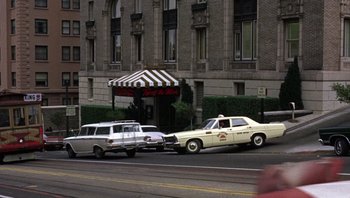 Movie still from “Bullitt” (1968), directed by Peter Yates – A couple of cars parked next to each other on the side of the road; Wide shot, Low angle