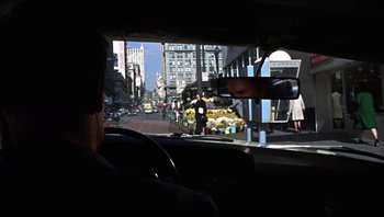 Movie still from “Bullitt” (1968), directed by Peter Yates – A view from inside a car looking out the window at a busy street; Wide shot, Over the shoulder angle