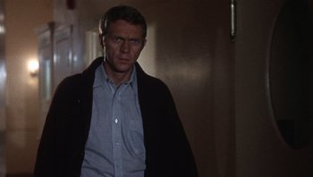Movie still from “Bullitt” (1968), directed by Peter Yates – A man standing in a hallway wearing a blue shirt; Medium shot, Low angle