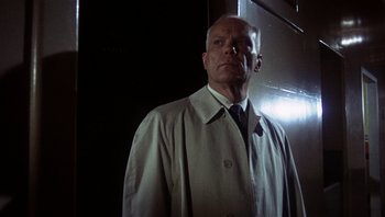 Movie still from “Bullitt” (1968), directed by Peter Yates – A man wearing a white coat and a tie; Close Up shot, Low angle
