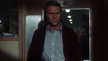 Movie still from “Bullitt” (1968), directed by Peter Yates – A man standing in front of a door; Medium shot, Low angle