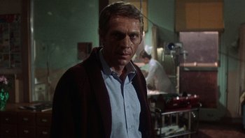 Movie still from “Bullitt” (1968), directed by Peter Yates – A man standing in front of a mirror in a room; Medium shot, Low angle