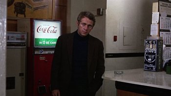 Movie still from “Bullitt” (1968), directed by Peter Yates – A man standing in front of a vending machine; Medium shot, Over the shoulder angle