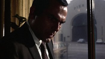 Movie still from “Bullitt” (1968), directed by Peter Yates – A person wearing a suit and tie; Close Up shot, Over the shoulder angle