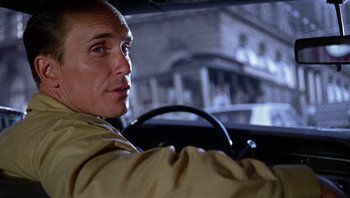 Movie still from “Bullitt” (1968), directed by Peter Yates – A person driving a car; Close Up shot, Over the shoulder angle