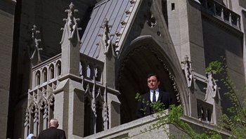 Movie still from “Bullitt” (1968), directed by Peter Yates – A man in a suit standing in front of a building; Wide shot, Low angle