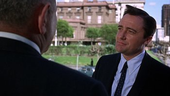 Movie still from “Bullitt” (1968), directed by Peter Yates – A man in a business suit talking to another man in a business suit; Close Up shot, Over the shoulder angle