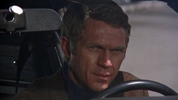 Movie still from “Bullitt” (1968), directed by Peter Yates – A person sitting in a car; Close Up shot, High angle