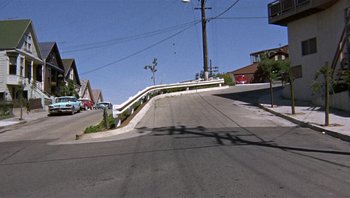 Movie still from “Bullitt” (1968), directed by Peter Yates – A view of a street from a moving vehicle; Extreme Wide shot, High angle