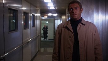 Movie still from “Bullitt” (1968), directed by Peter Yates – A man standing in the hallway of an office building; Medium shot, Over the shoulder angle