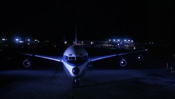 Movie still from “Bullitt” (1968), directed by Peter Yates – An airplane on the tarmac at night with lights on; Extreme Wide shot, Overhead angle